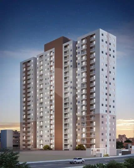 Fachada de edifício residencial moderno com tons de bege e marrom ao entardecer.